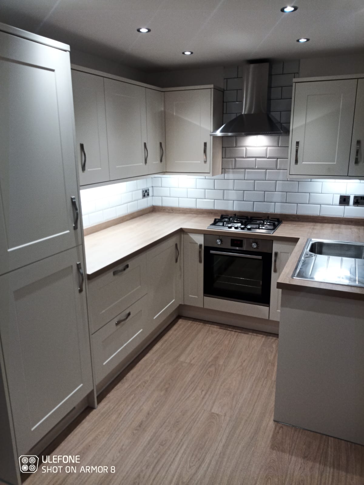 White Tiled kitchen with wood effect top and wood flooring installed by Kitchen Fitter in Barnsley at A - Z Home Renovations 2